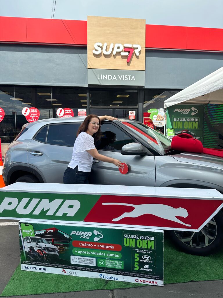 Ganadora del sorteo Puma Energy 2025 posando junto a su Hyundai Creta frente a la estación Super 7 Linda Vista en Managua.