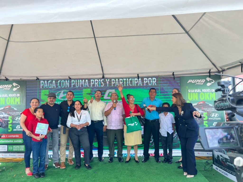Grupo de ganadores, familiares y representantes de Puma Energy celebrando juntos en el escenario del evento.