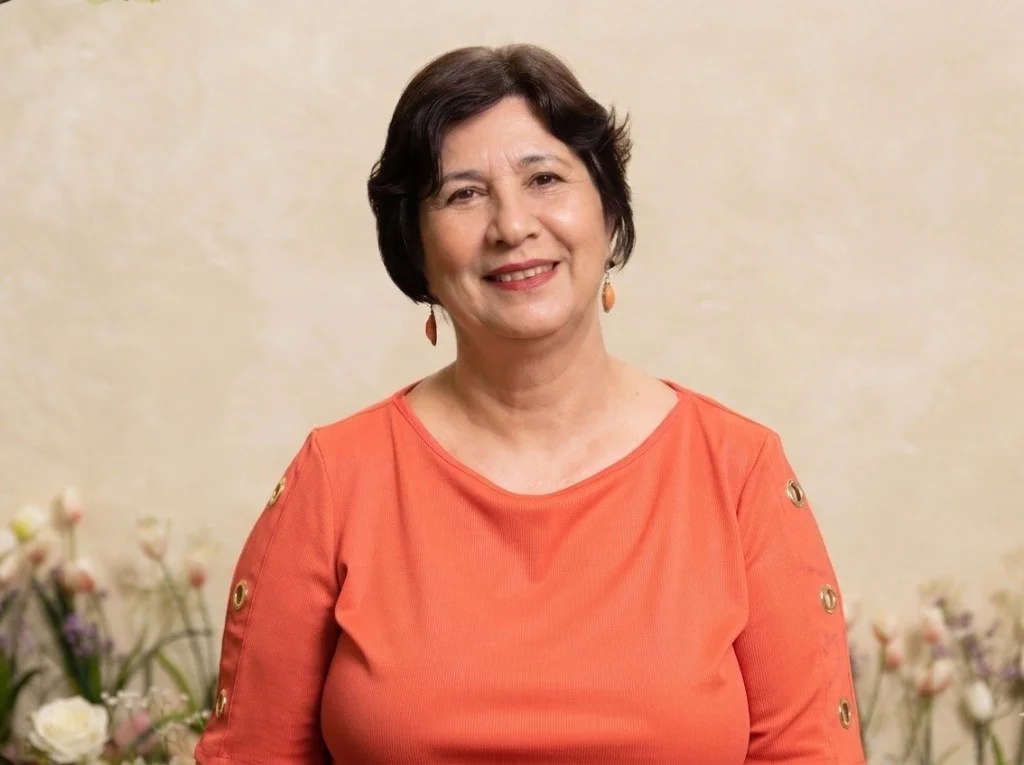 Rosario Montenegro la madre nicaragüense que construyó su liderazgo de la mano de su hijo Retrato de una madre nicaragüense sonriendo frente a un fondo neutro con detalles florales desenfocados." Si el objetivo es SEO para una nota o perfil biográfico, conviene añadir su nombre: