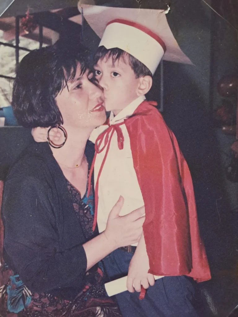 Madre nicaragüense abrazando a su hijo durante una ceremonia de graduación infantil, en una fotografía familiar de recuerdo.